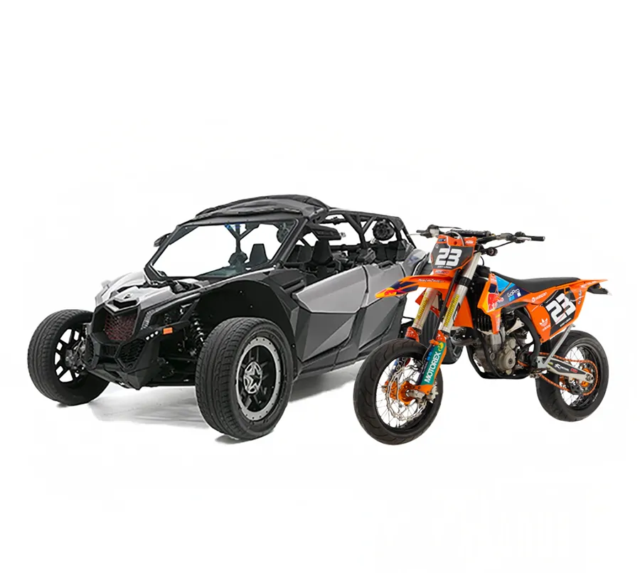 A black and gray off-road side-by-side beside an orange dirt bike